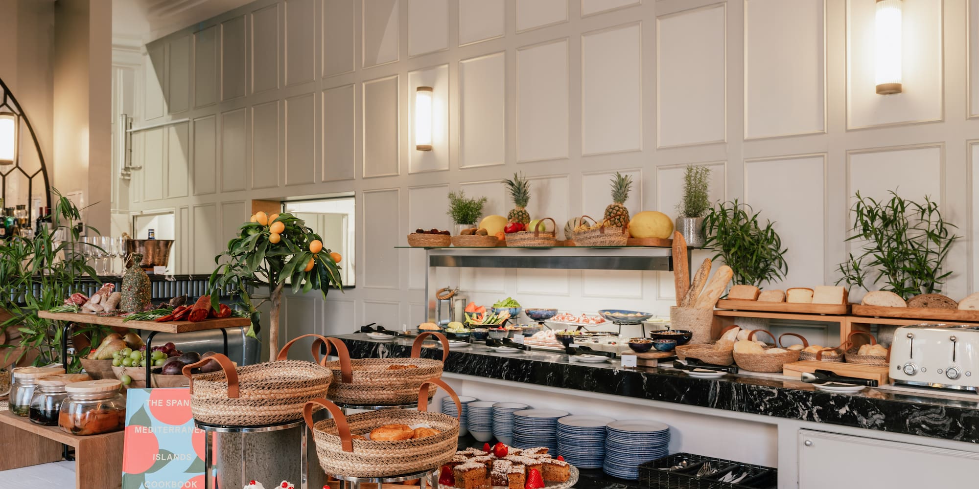 Elegant hotel breakfast buffet: pastries, fresh fruit, bread, and charcuterie.