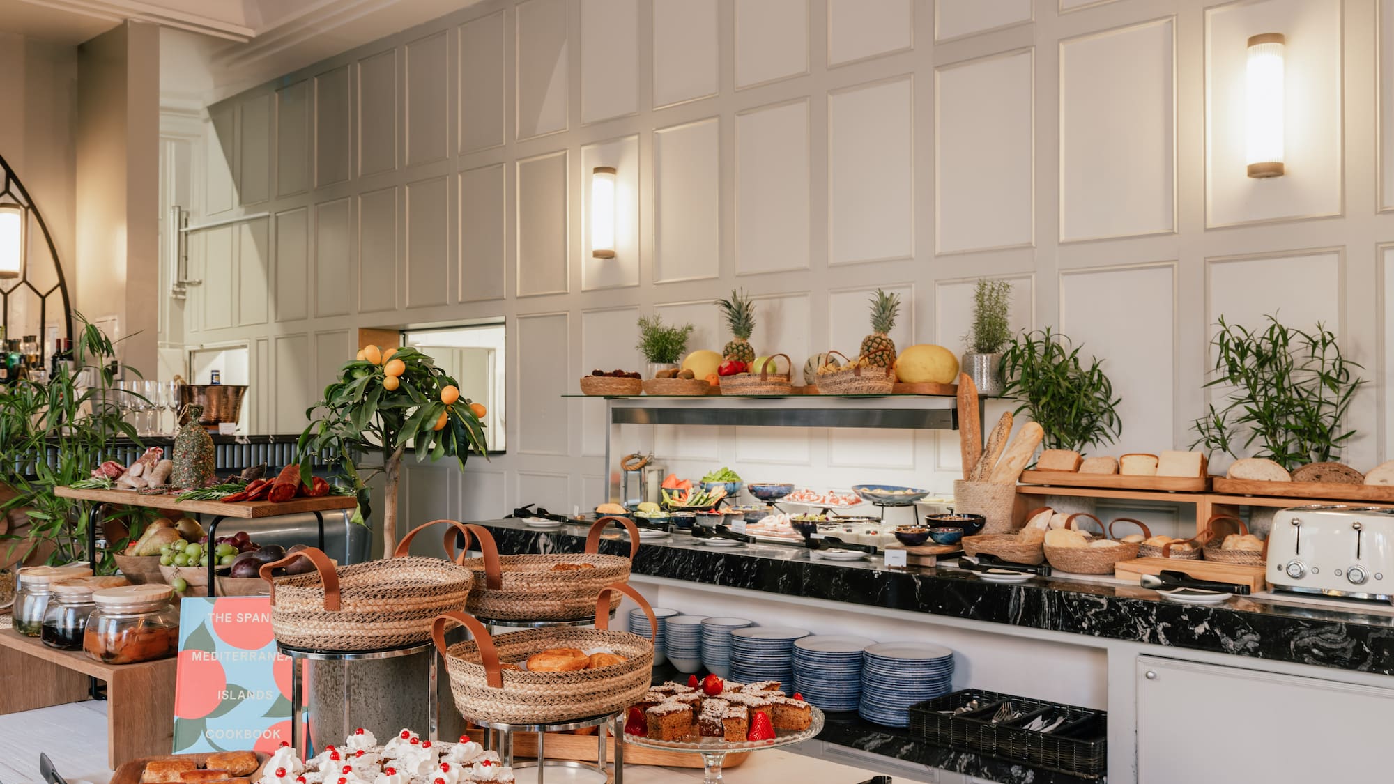 Elegant hotel breakfast buffet: pastries, fresh fruit, bread, and charcuterie.
