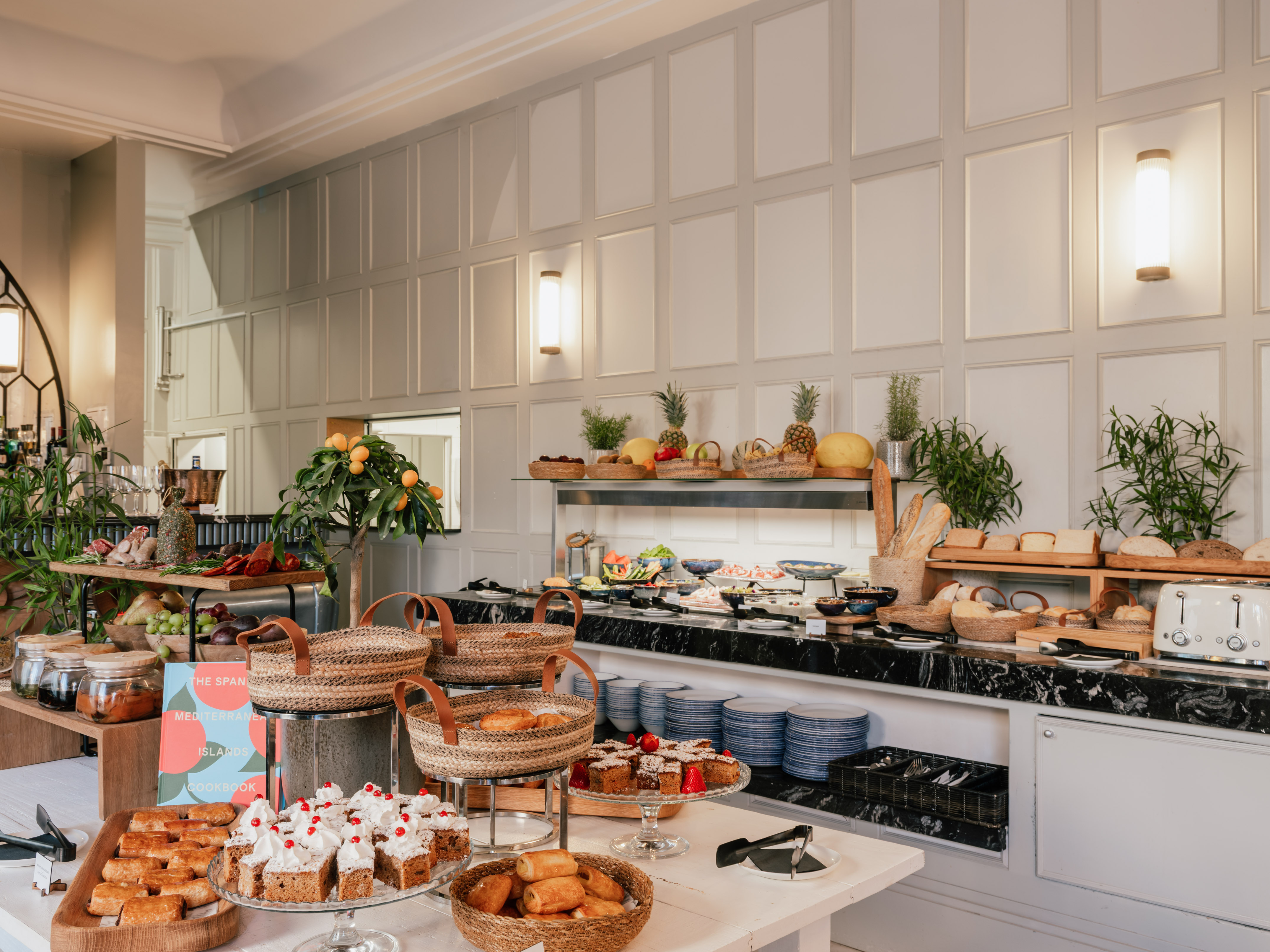 Elegant hotel breakfast buffet: pastries, fresh fruit, bread, and charcuterie.