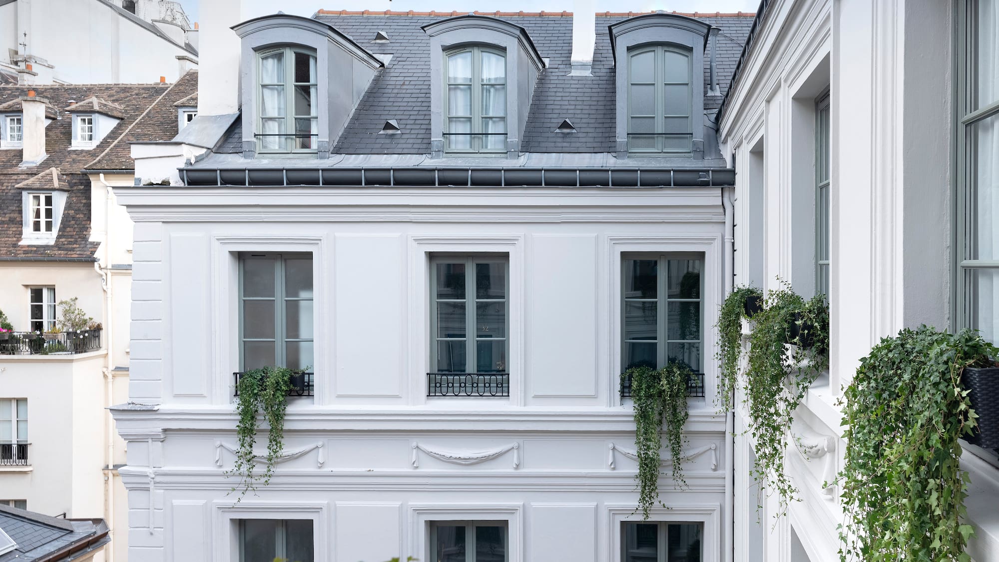 a white building with plants on the side