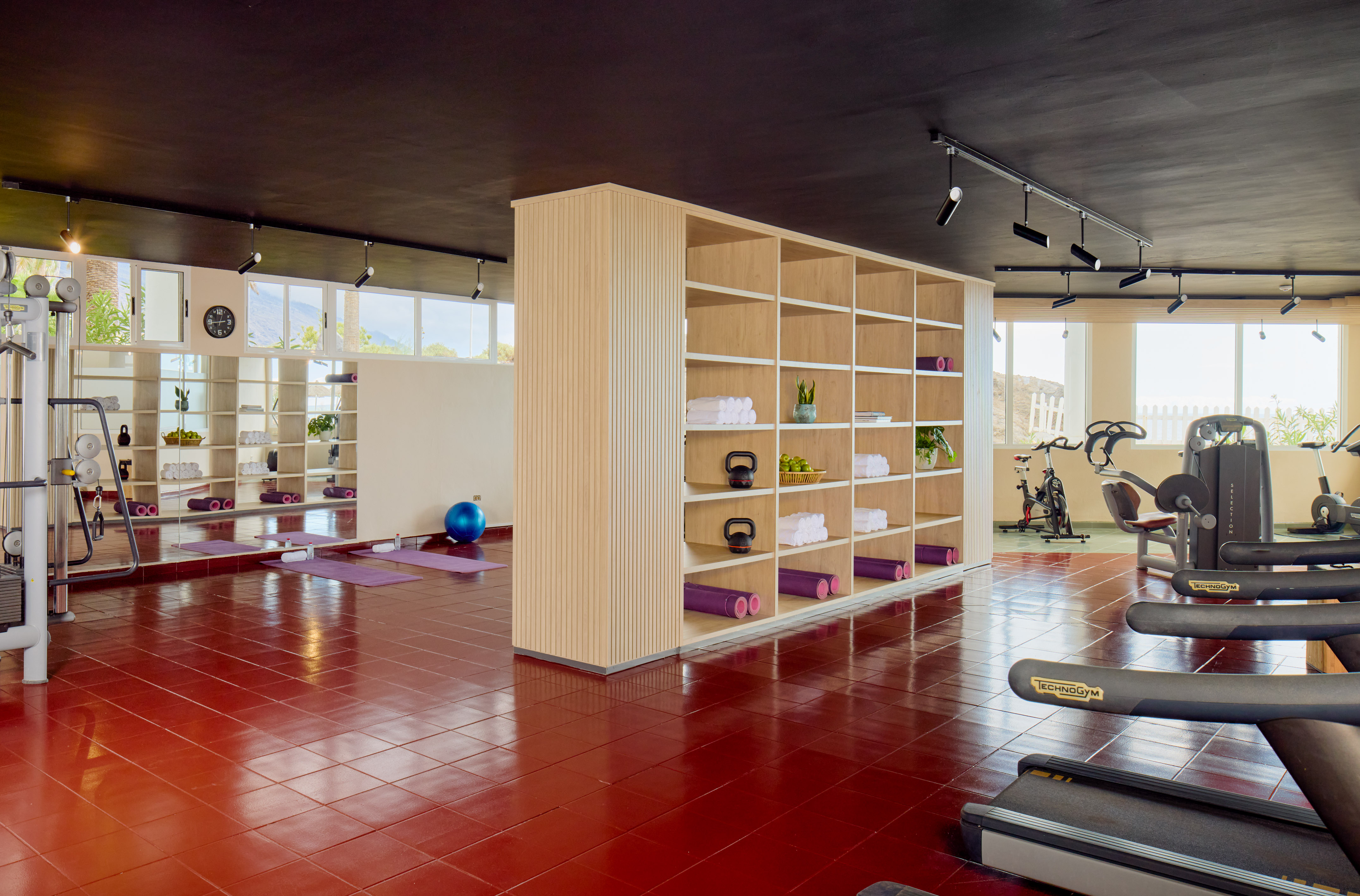 Bright fitness center with exercise equipment, yoga area, and scenic windows.