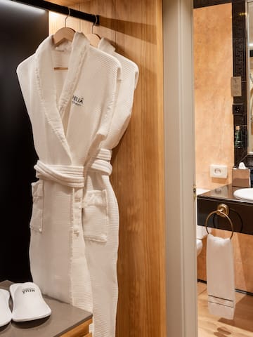 a white robe on a rack in a bathroom