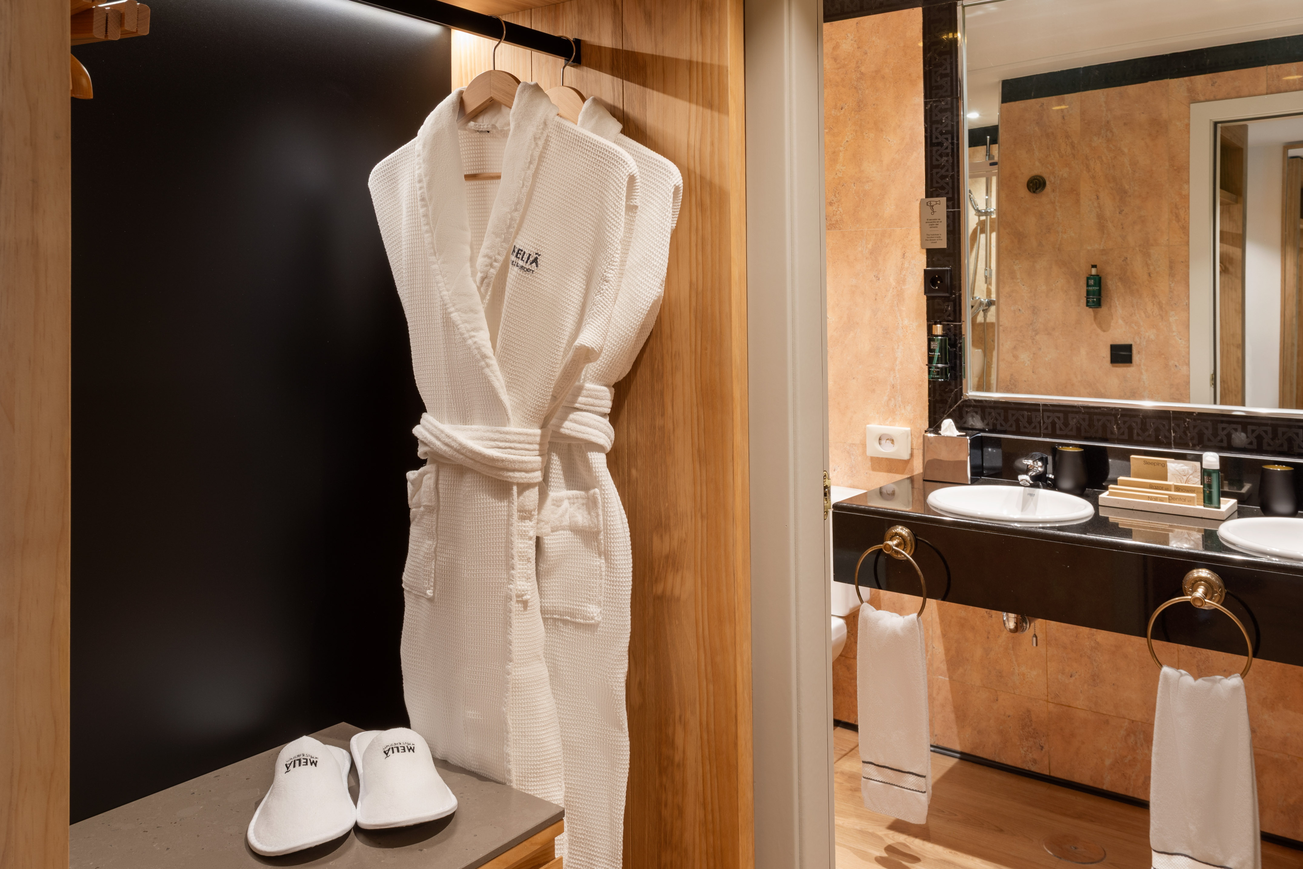 Luxury hotel amenities: Meliá bathrobe, slippers, and bathroom vanity.