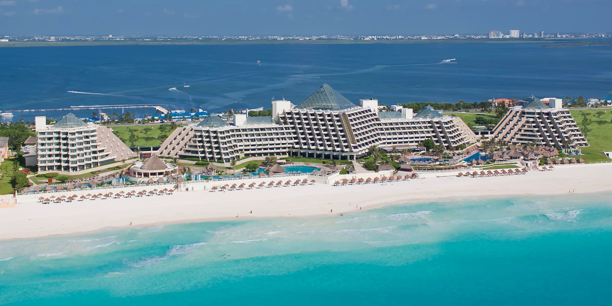 a beach with a large building and a body of water