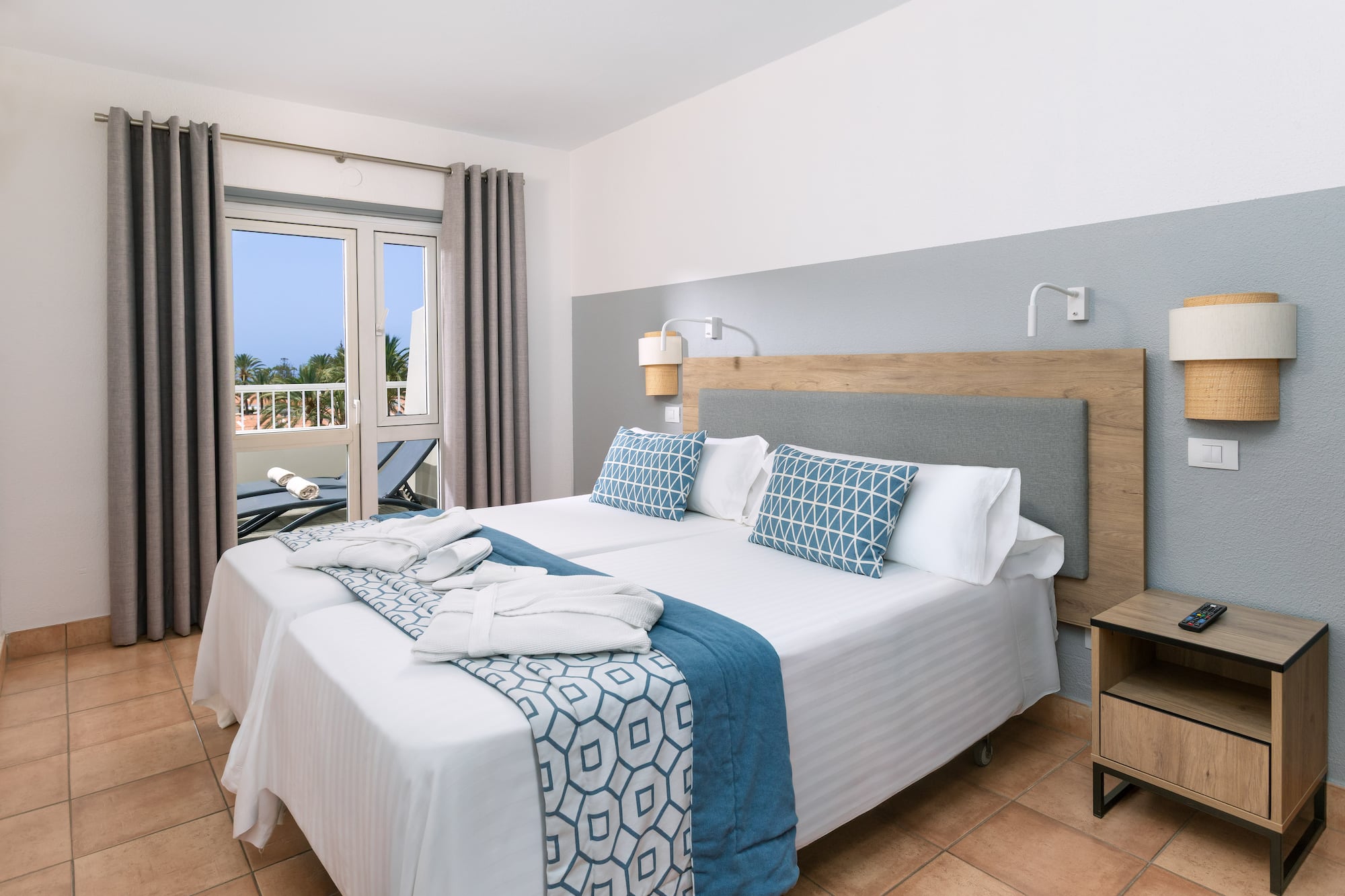 a bed with white and blue blankets and pillows