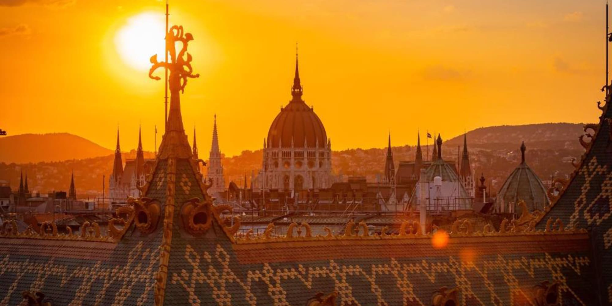 a rooftop of a city with a sunset behind it