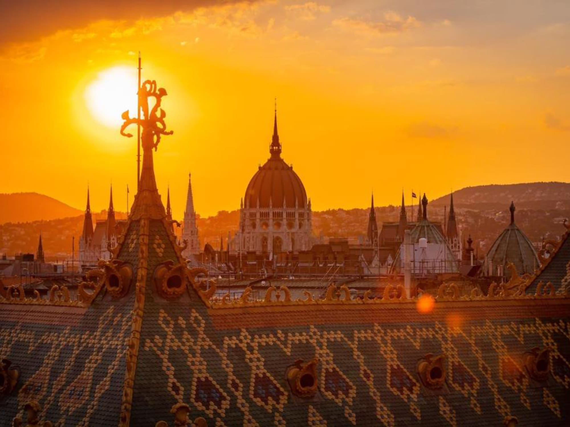 a rooftop of a city with a sunset behind it