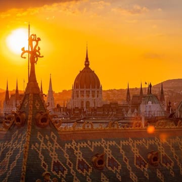 a rooftop of a city with a sunset behind it