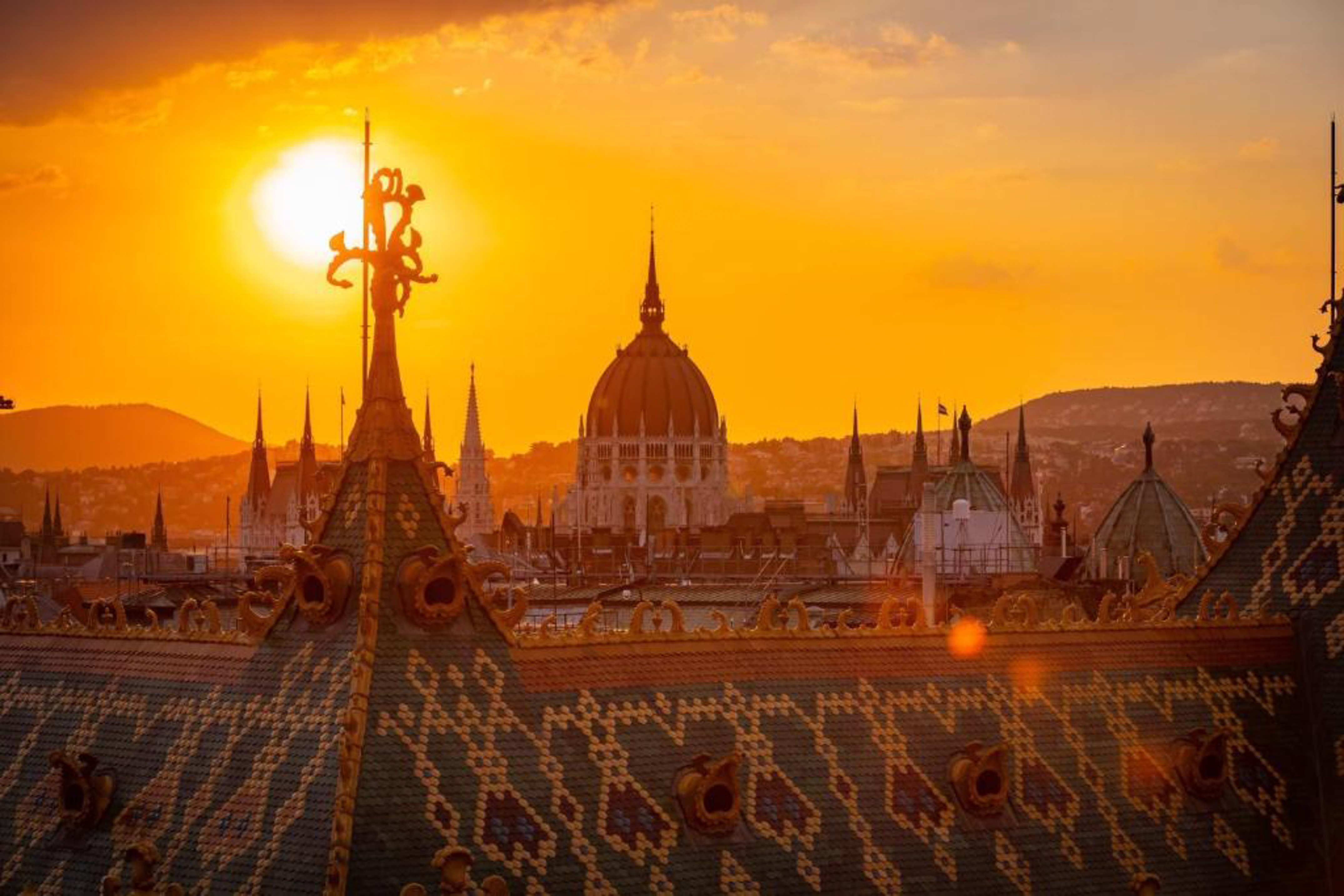 a rooftop of a city with a sunset behind it