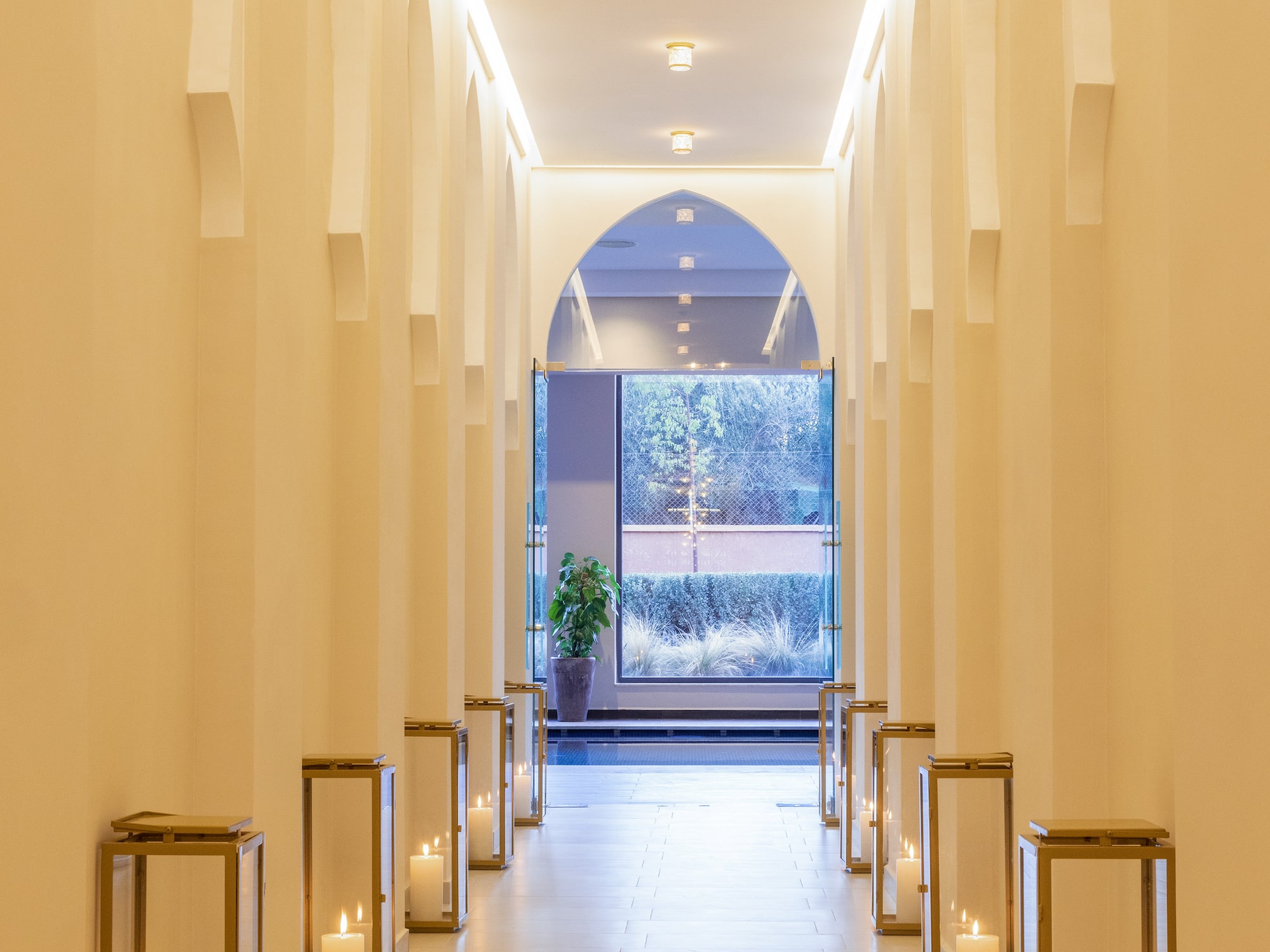 a hallway with white pillars and lit candles