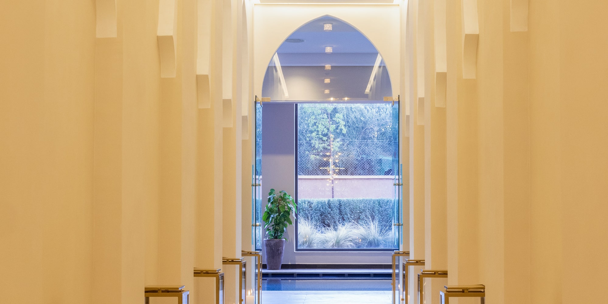 a hallway with white pillars and lit candles