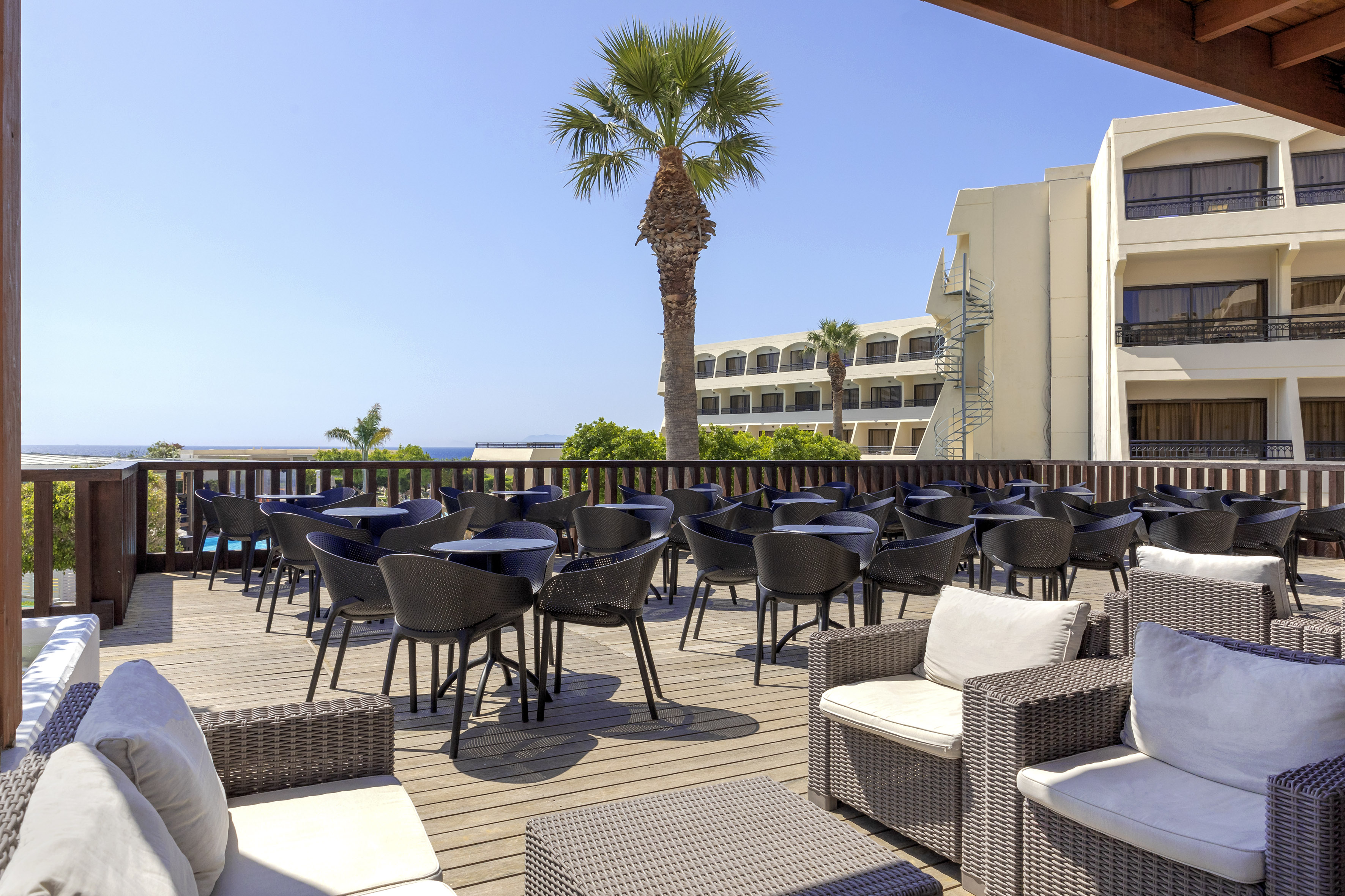 a patio with chairs and tables on a deck