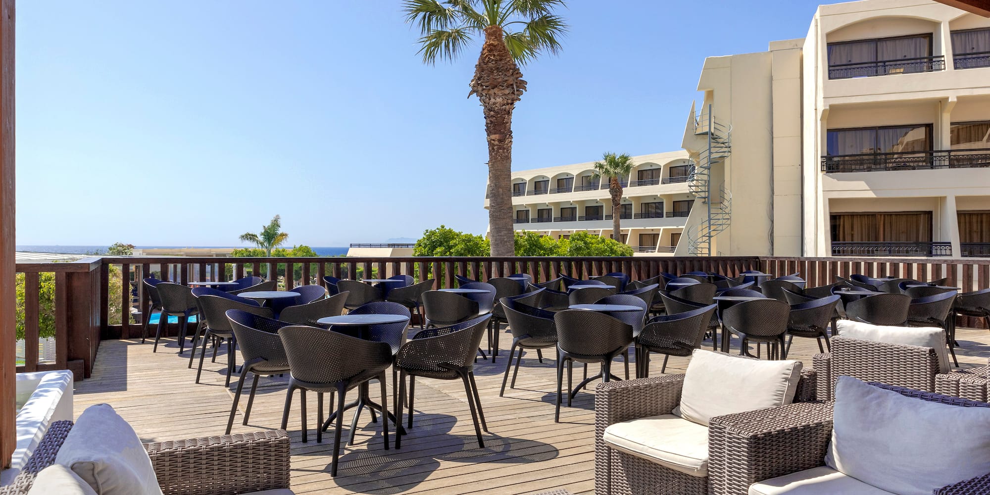 a patio with chairs and tables on a deck