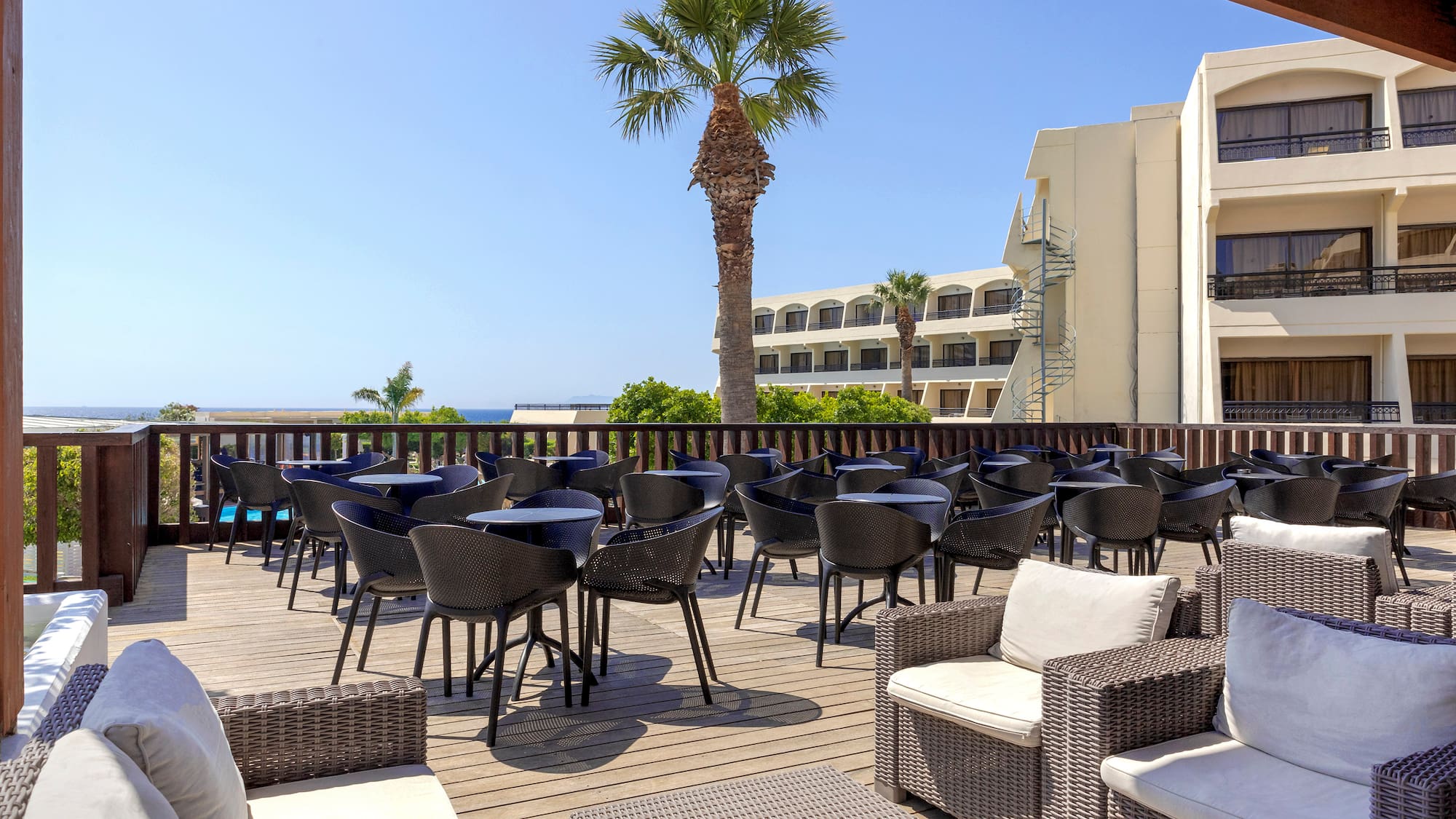 a patio with chairs and tables on a deck