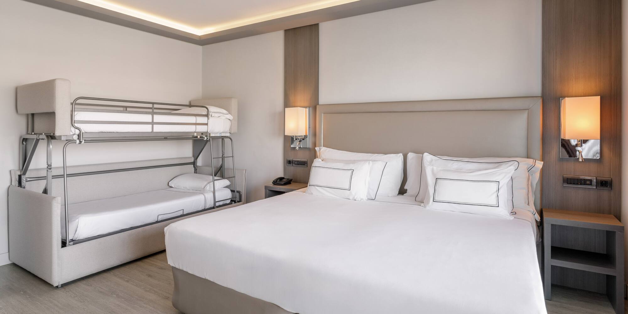 Habitación familiar de hotel moderna con cama doble, litera y cama supletoria.
