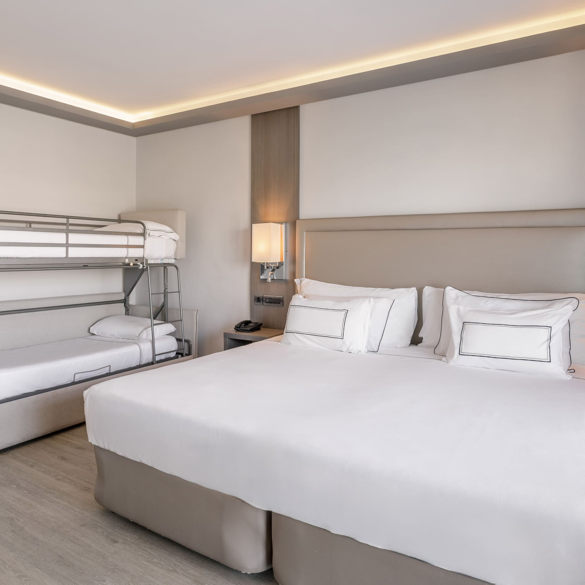 Habitación familiar de hotel moderna con cama doble, litera y cama supletoria.