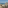 Balcony with ocean view, sandy beach, desert plants, chairs, and table.