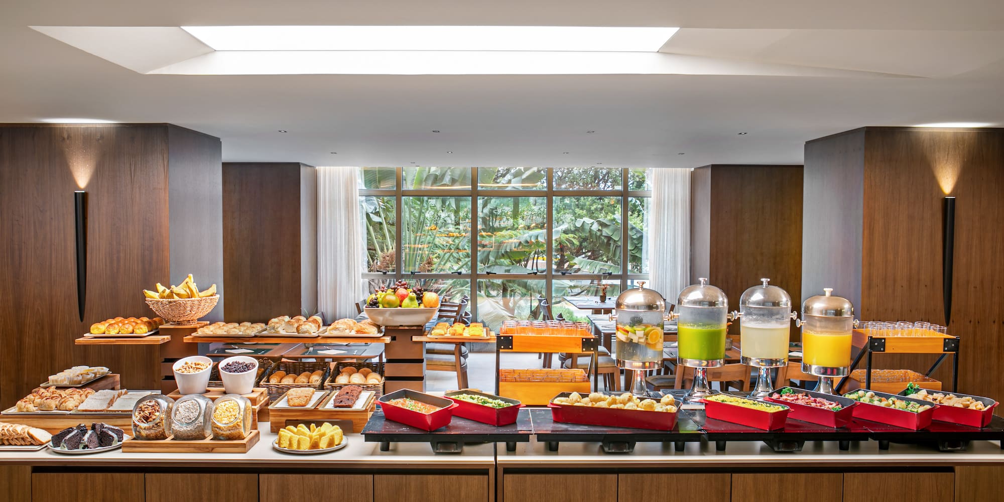 Extensive hotel breakfast buffet with pastries, fruit, juices, and hot food.
