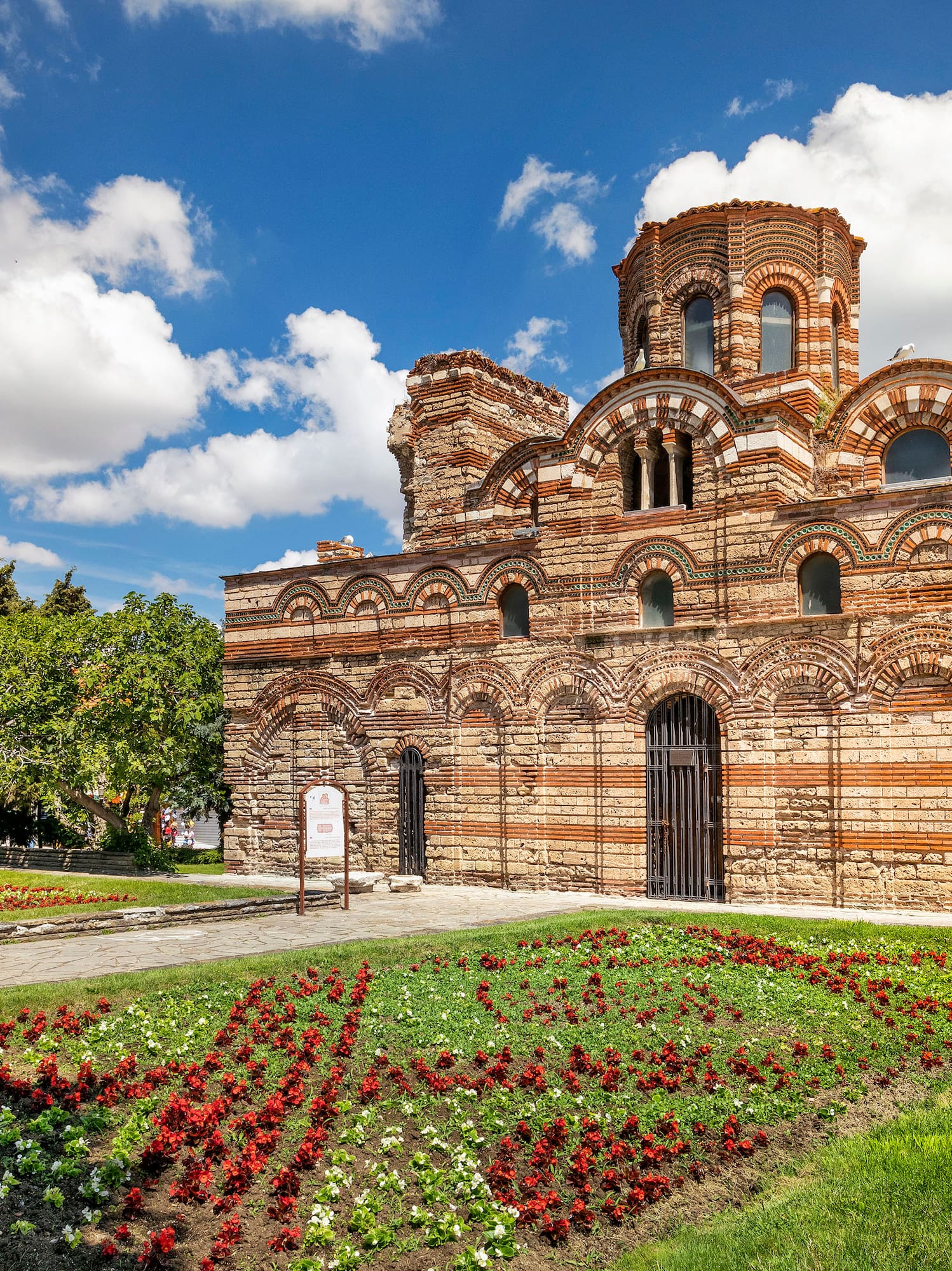 a brick building with a garden and flowers