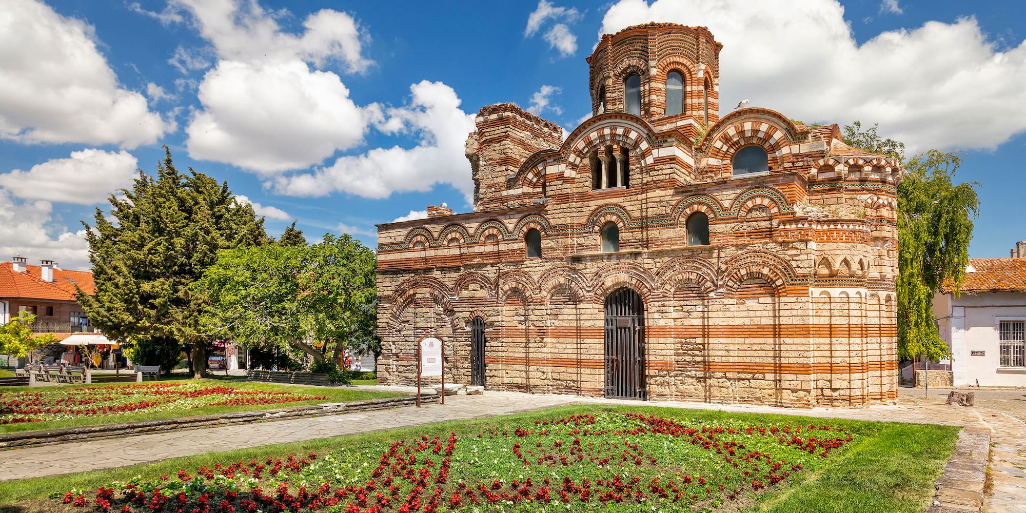 a brick building with a garden and flowers