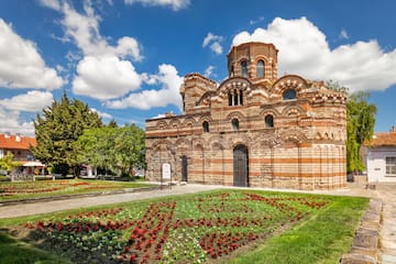 a brick building with a garden and flowers