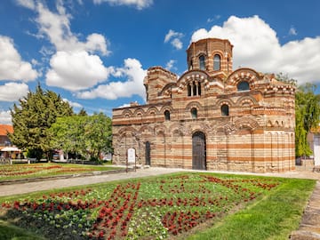 a brick building with a garden and flowers