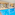 Indoor hotel swimming pool with blue water, lounge chairs, and plants.