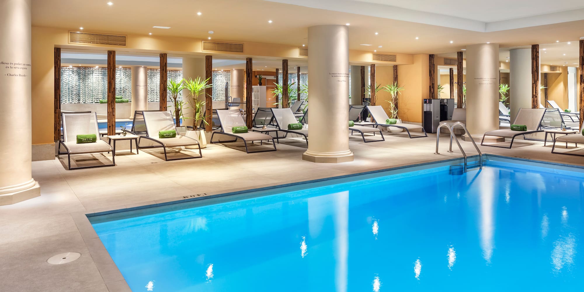 a pool with lounge chairs and a large building