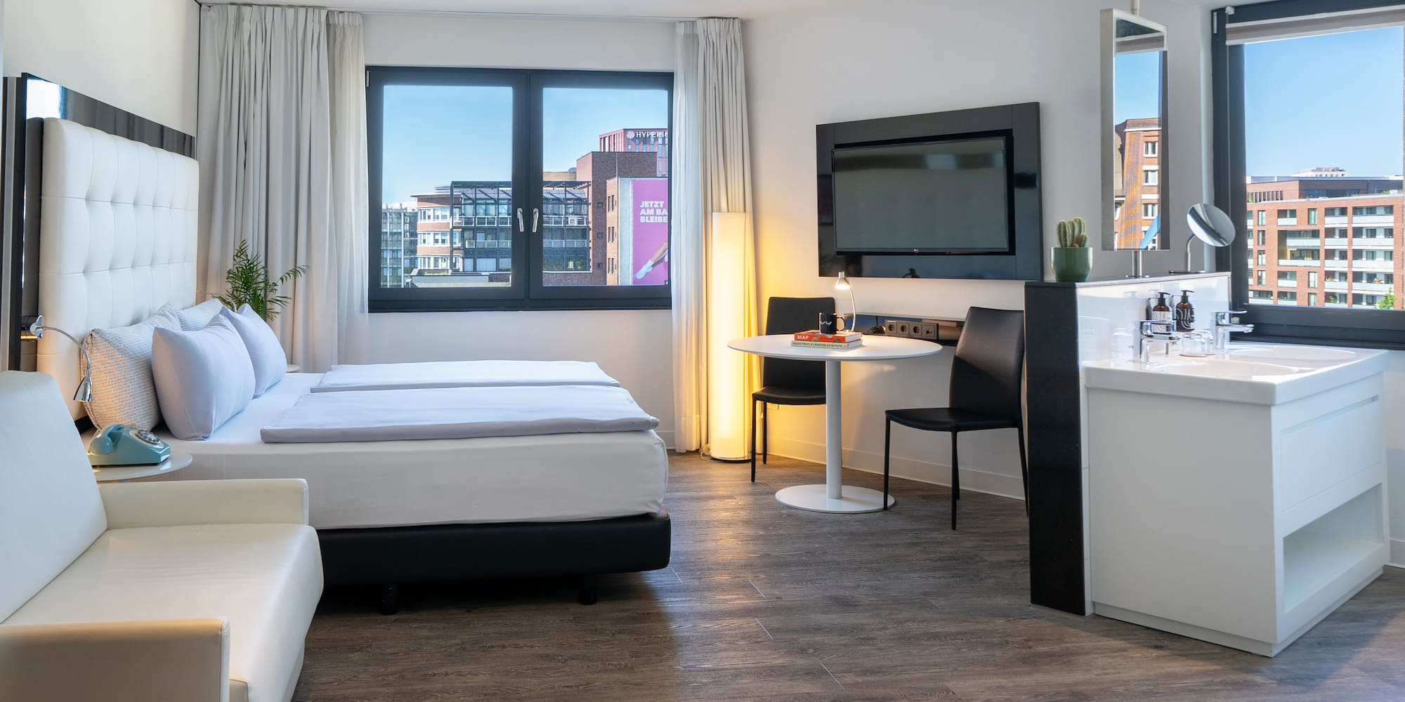 a room with a bed and a table and a television