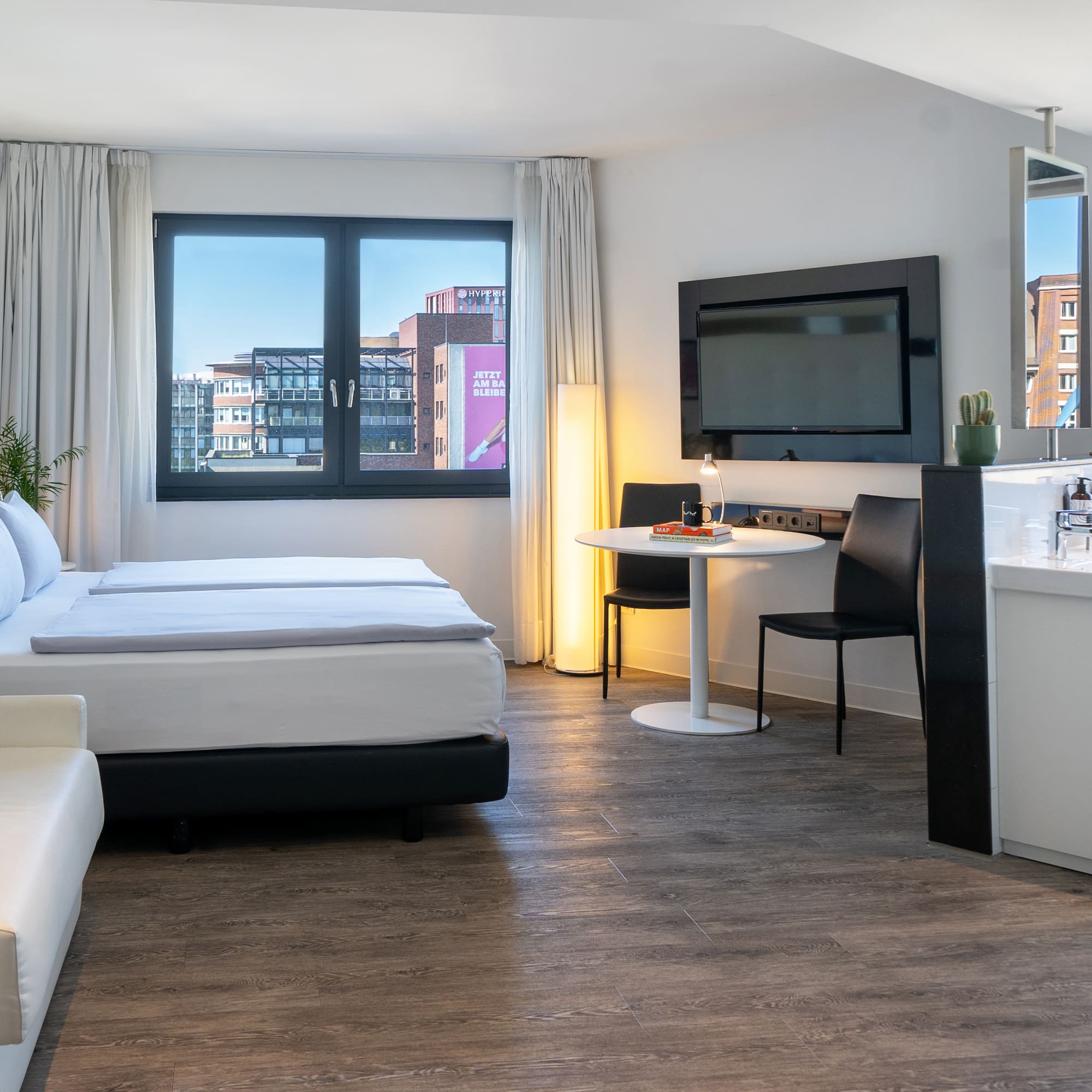 a room with a bed and a table and a television