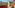 Sunny balcony with outdoor seating, mountain and resort views, tropical plants.