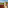 Sunny balcony with outdoor seating, mountain and resort views, tropical plants.