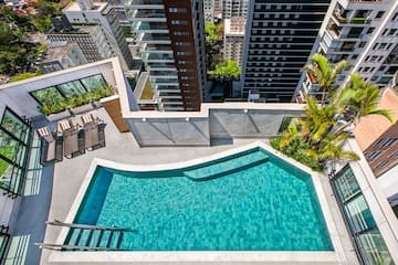 a pool with a ladder and a city view