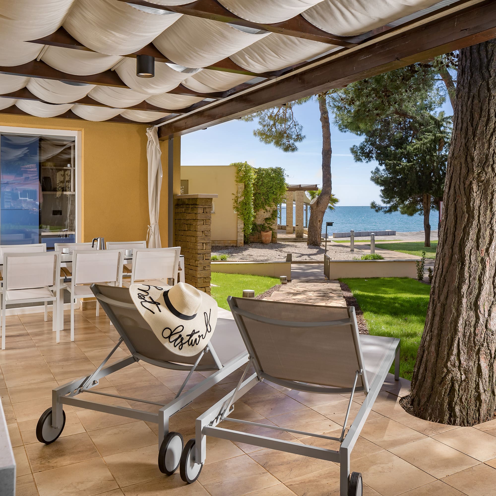 a deck with chairs and a tree and a large tree