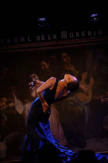 a woman in a black dress dancing on a stage