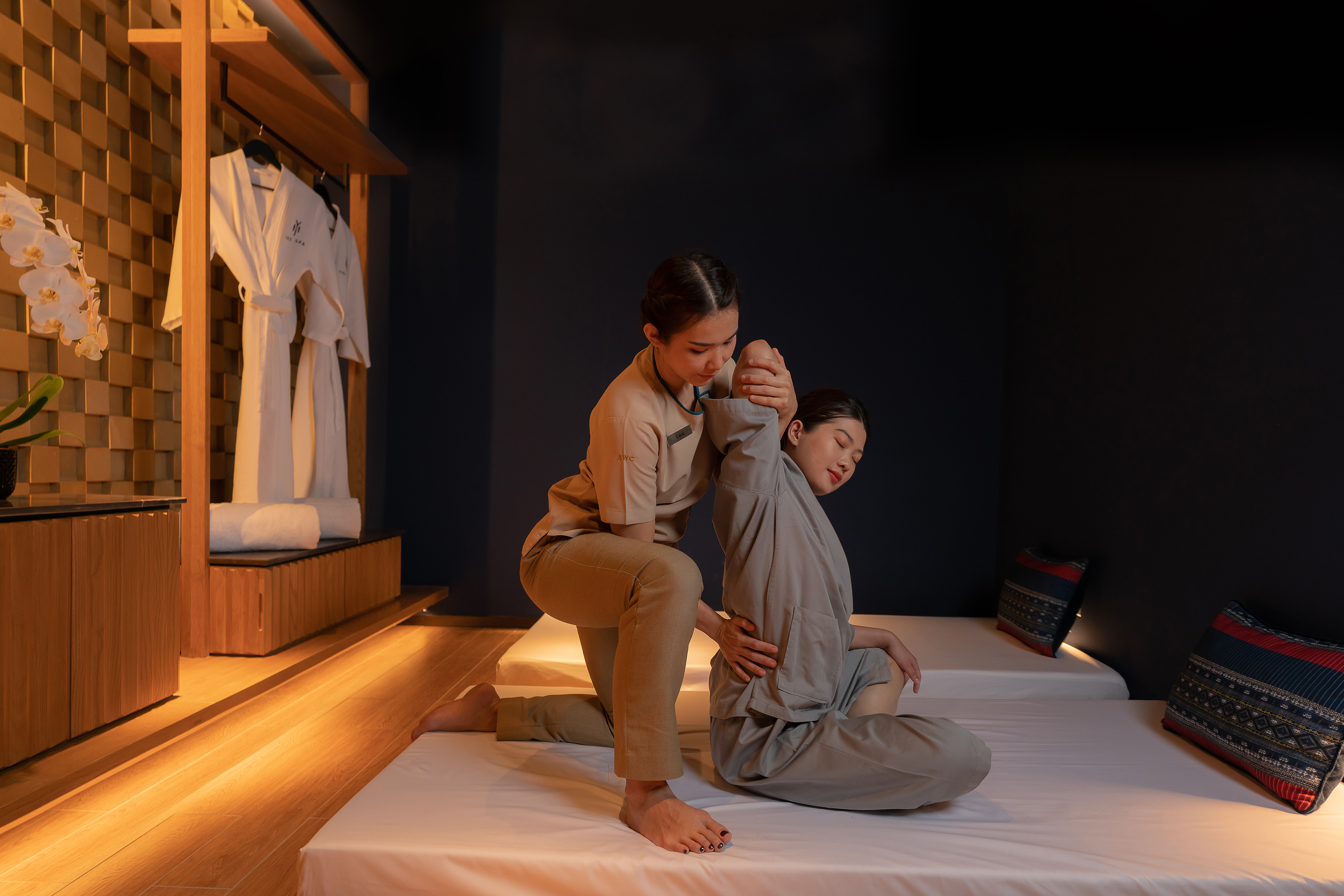 Massage therapist stretching client in a serene spa room.