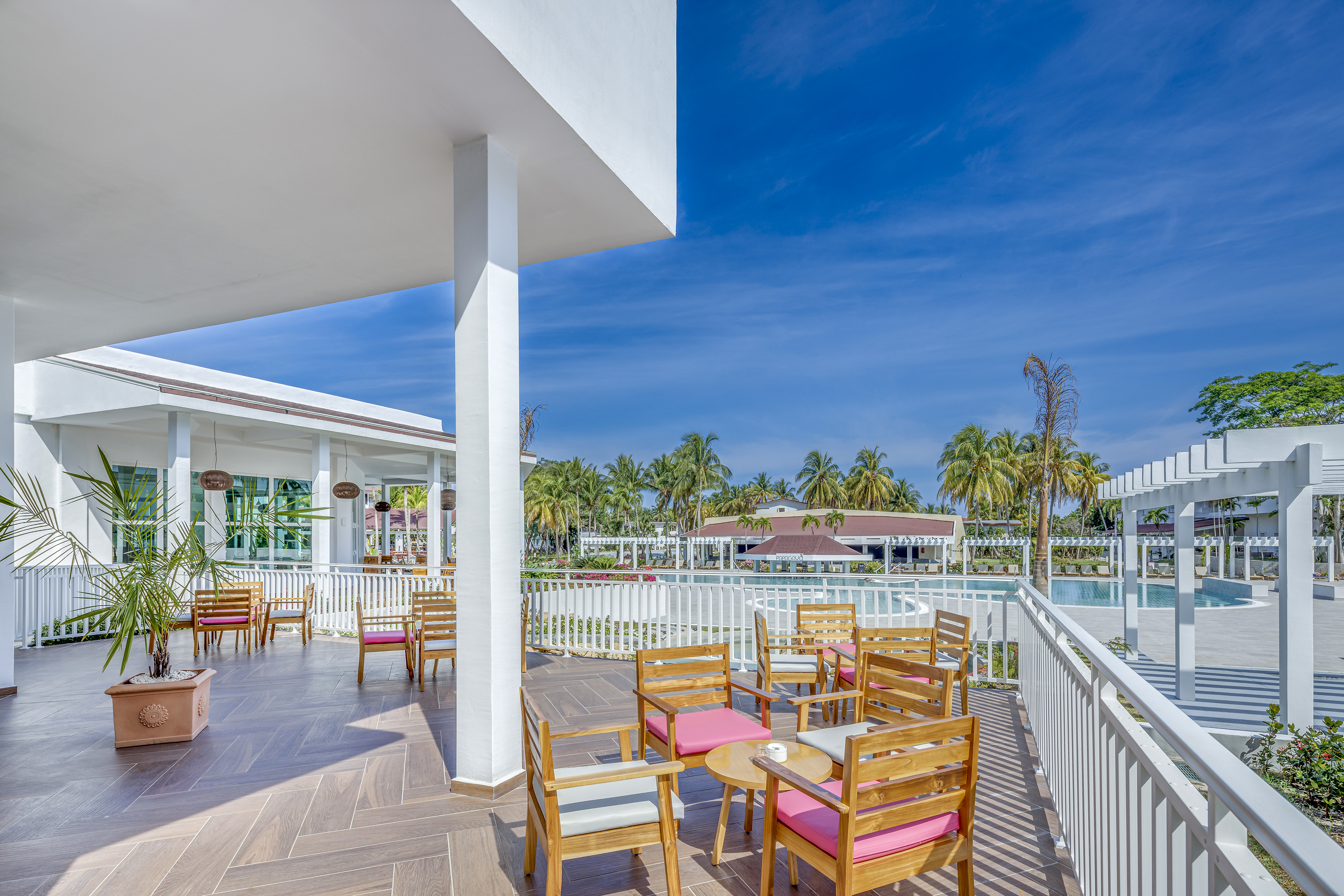 a patio with chairs and tables on a deck