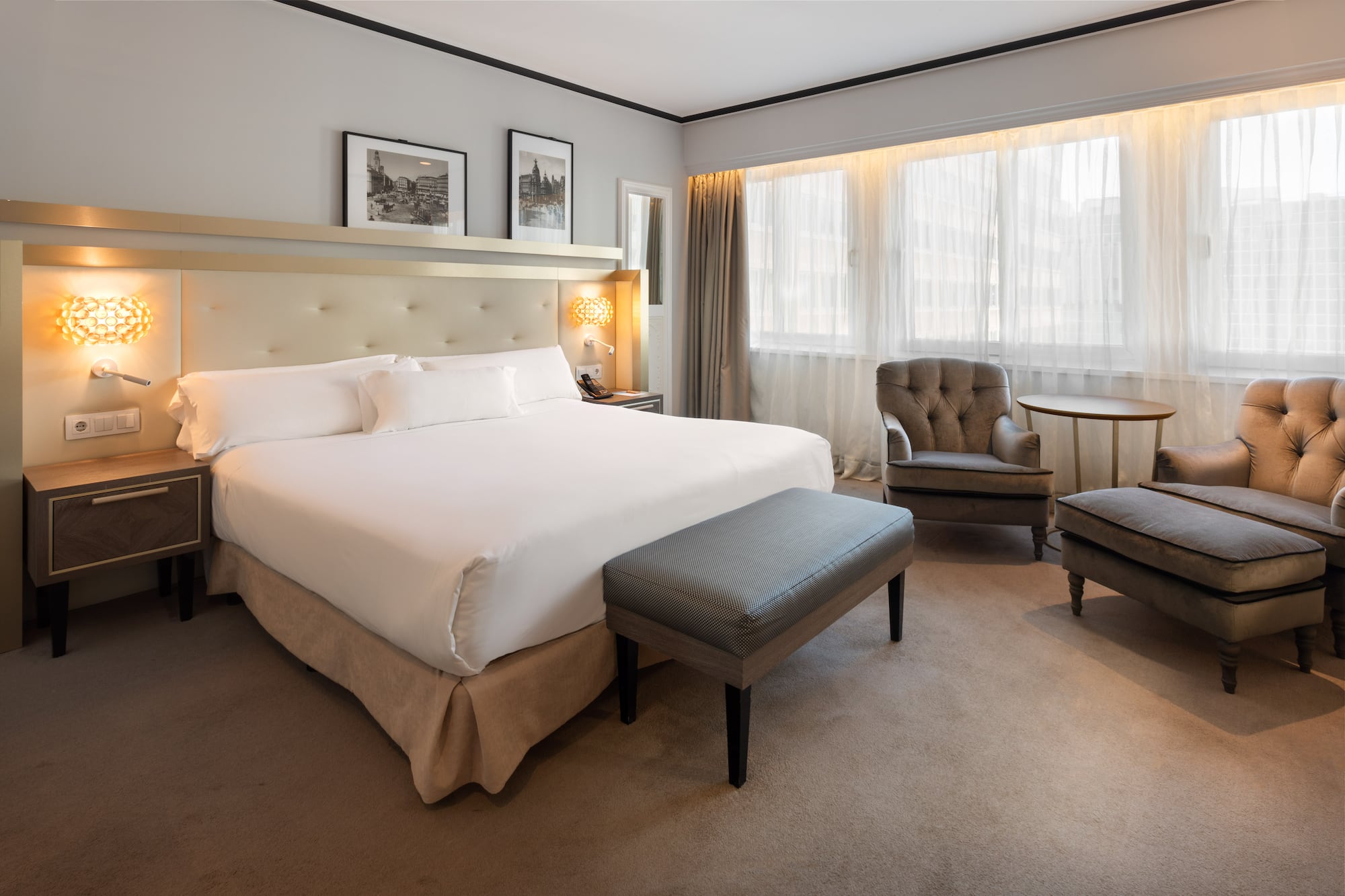 a bedroom with a bed and chairs