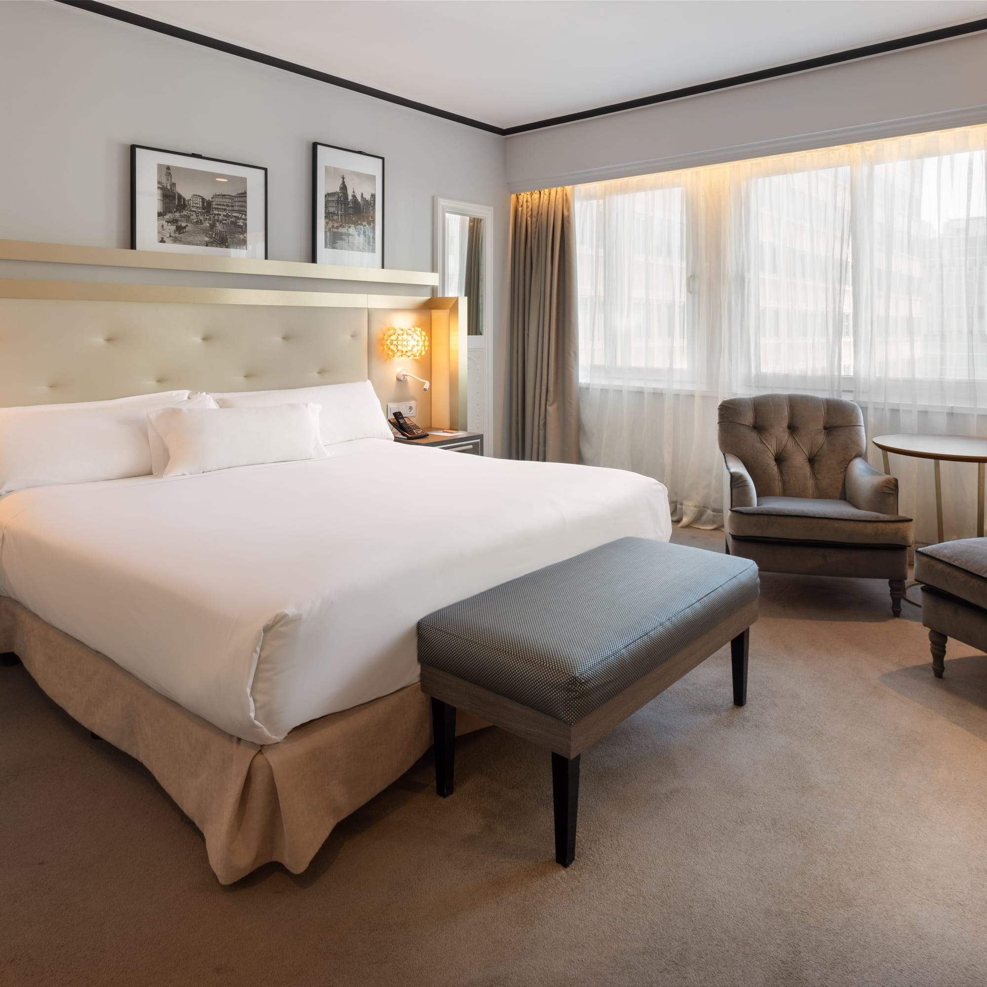 a bedroom with a bed and chairs