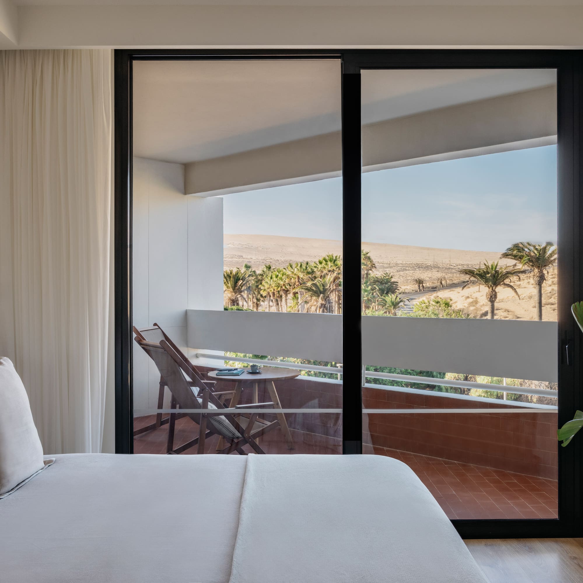 a bed with a glass door and a balcony