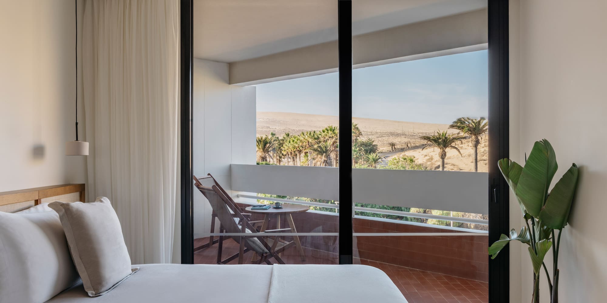 a bed with a glass door and a balcony