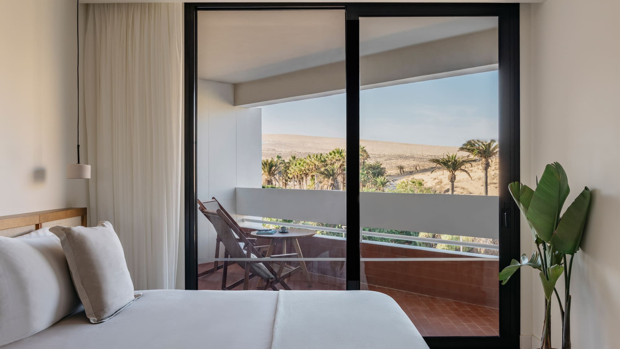 a bed with a glass door and a balcony