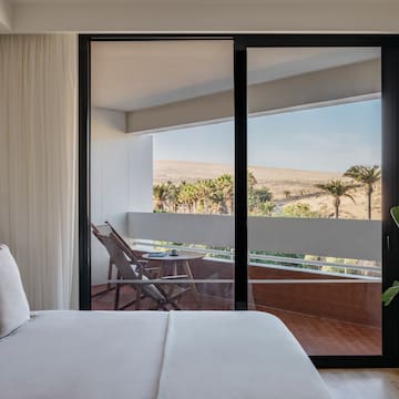a bed with a glass door and a balcony
