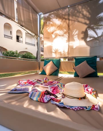 a sun lounger with a hat and a book on it