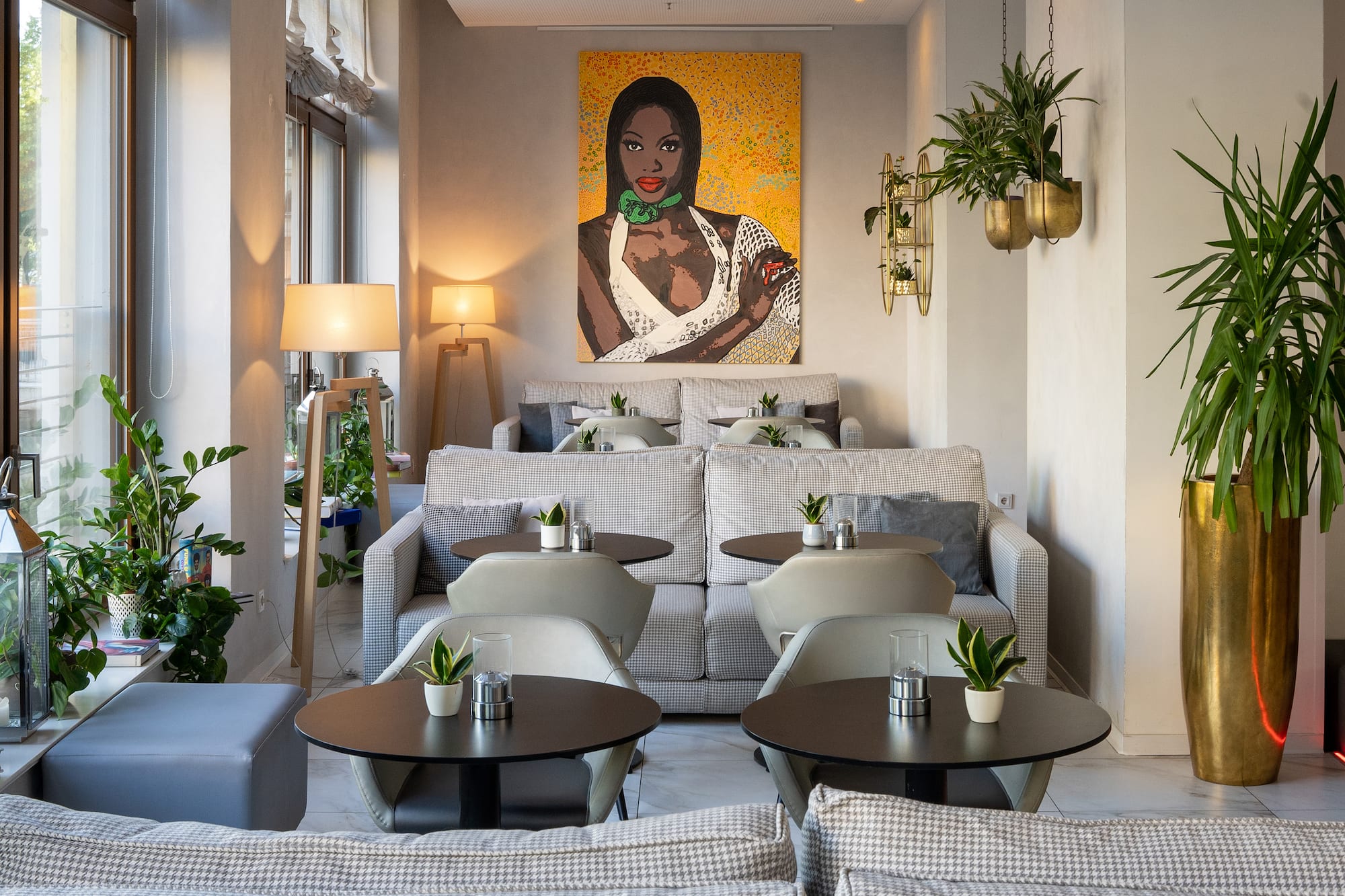 a room with tables and chairs and a painting on the wall