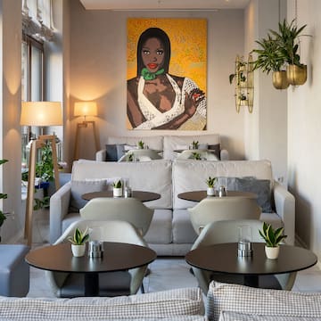 a room with tables and chairs and a painting on the wall