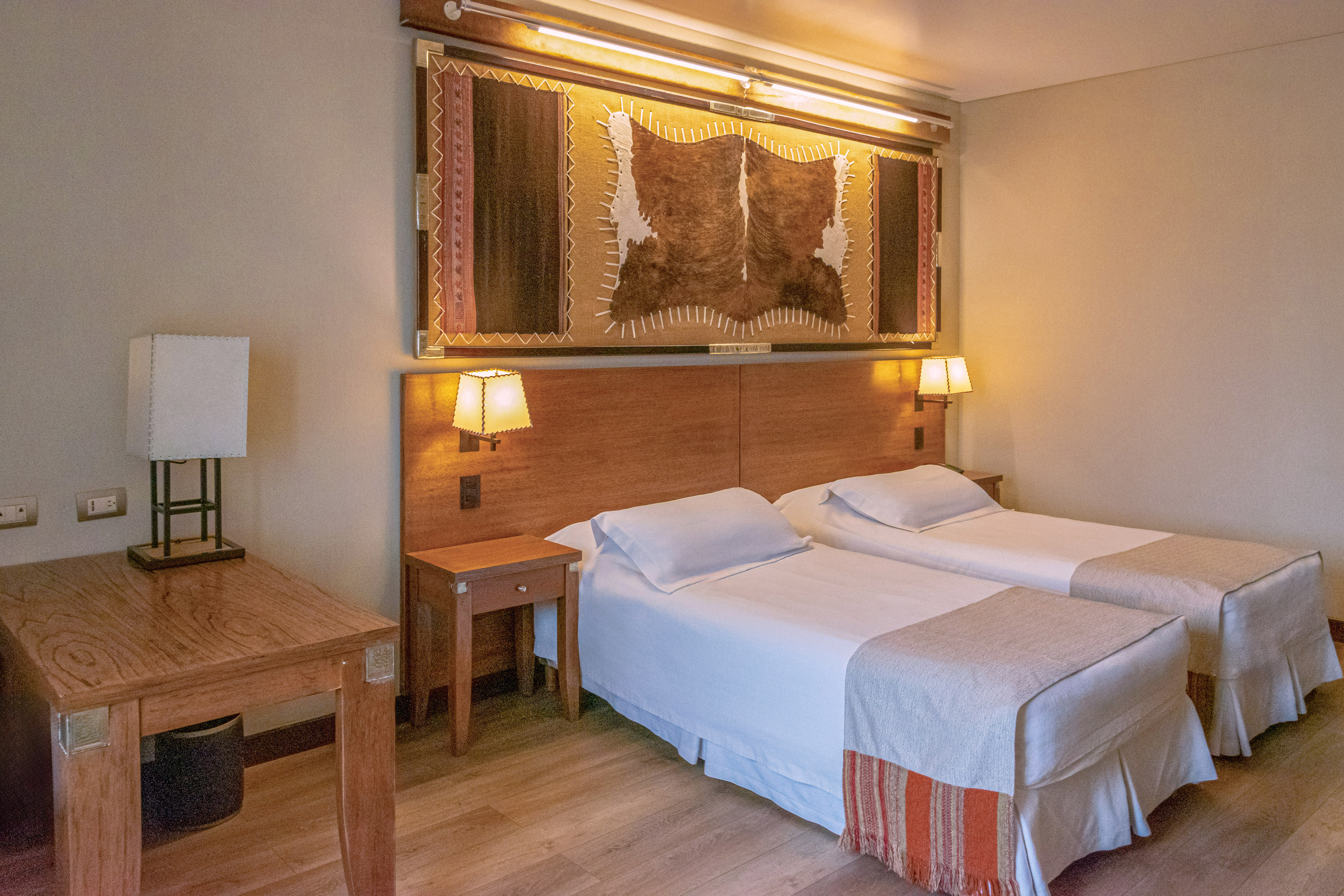 a room with two beds and a lamp