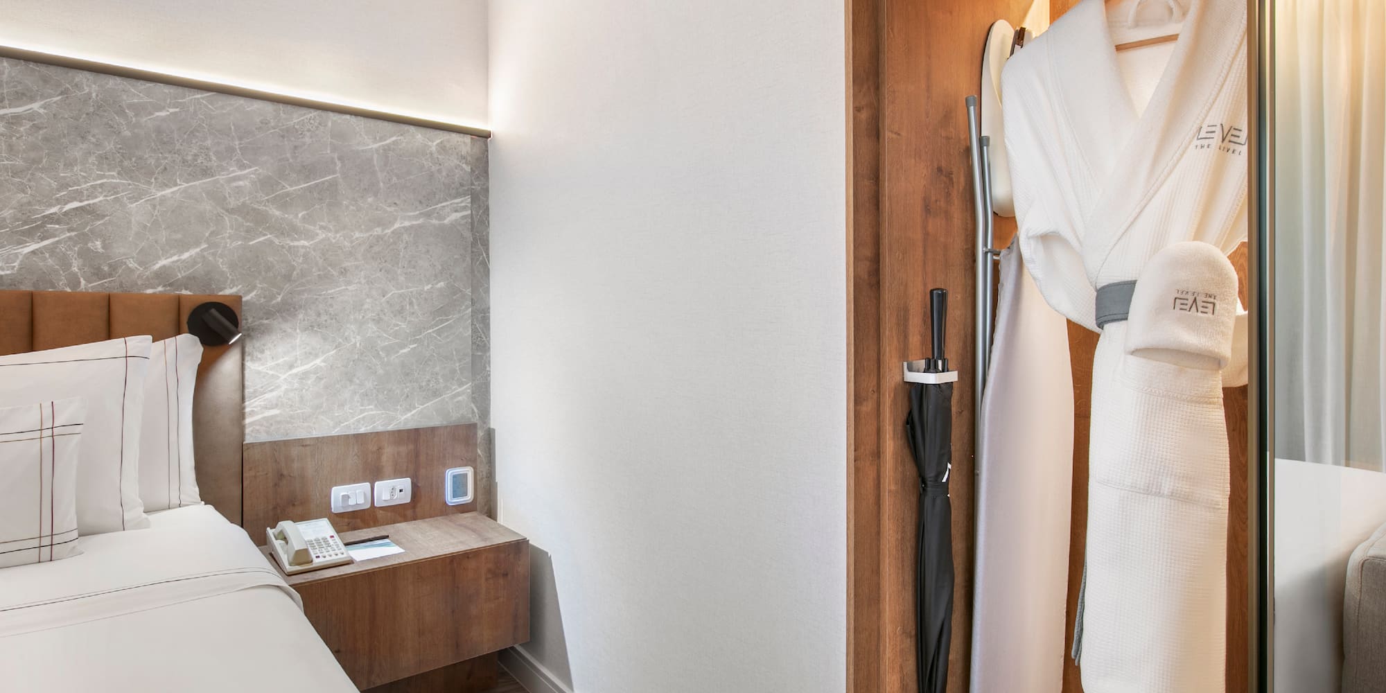 a room with a bed and a robe in a closet