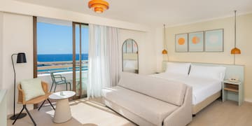 a room with a bed and a chair and a table