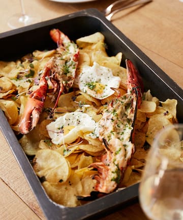 a plate of food with lobsters and potato chips